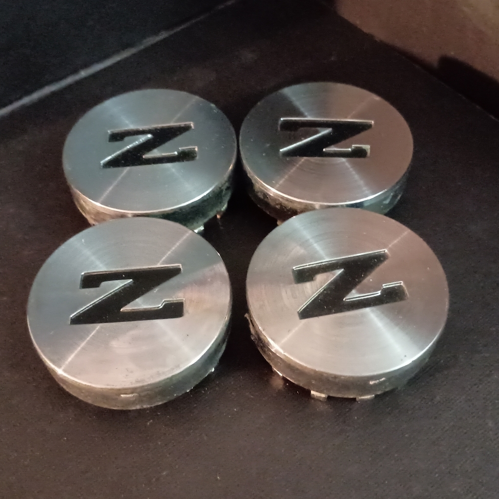 4 used Nissan z car wheel center caps USED